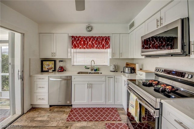 kitchen with appliances with stainless steel finishes, white cabinetry, and sink