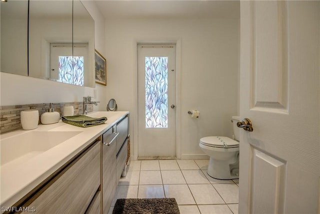 bathroom featuring tile patterned flooring, vanity, toilet, and tasteful backsplash