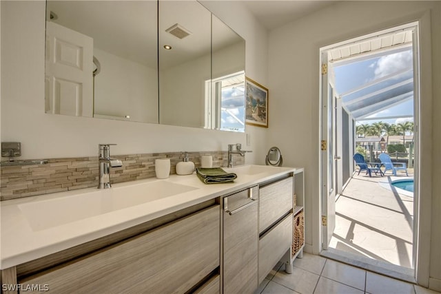 bathroom with tile patterned flooring, a healthy amount of sunlight, vanity, and lofted ceiling