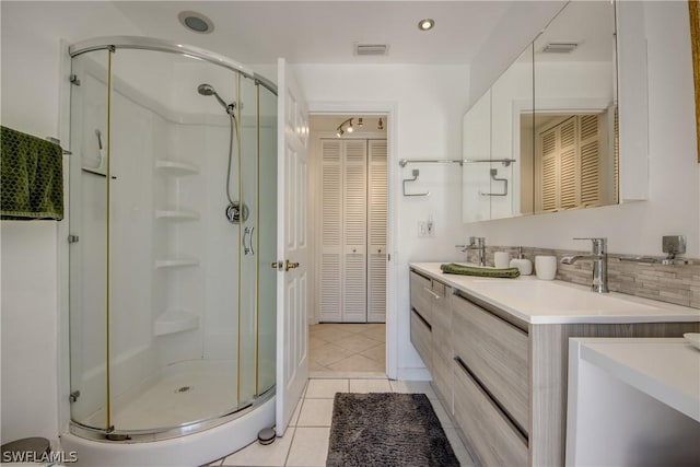 bathroom with backsplash, tile patterned flooring, vanity, and walk in shower