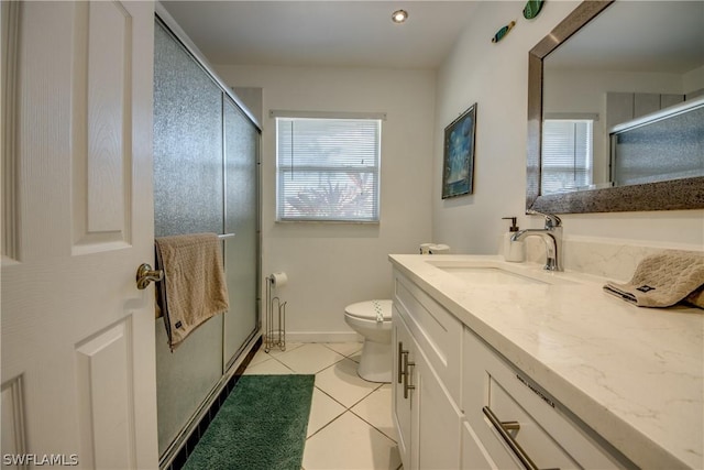 bathroom featuring tile patterned flooring, vanity, toilet, and a shower with shower door