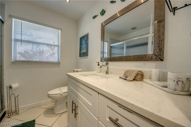 bathroom featuring toilet, vanity, tile patterned floors, and a shower with door