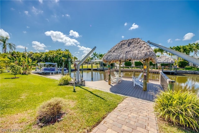 view of dock with a gazebo, a lawn, and a water view