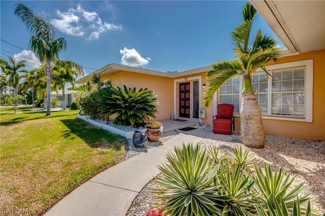 doorway to property featuring a lawn