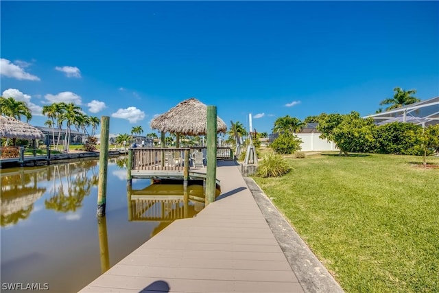 view of dock with a yard and a water view