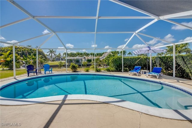 view of pool with a patio and glass enclosure