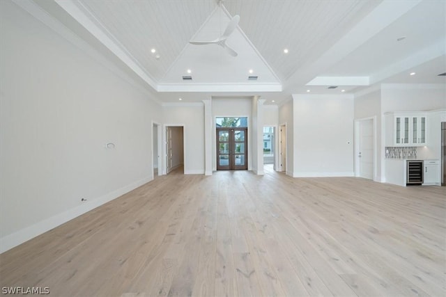 unfurnished living room with french doors, crown molding, wine cooler, ceiling fan, and light hardwood / wood-style floors