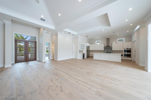 unfurnished living room with light hardwood / wood-style floors, crown molding, and french doors