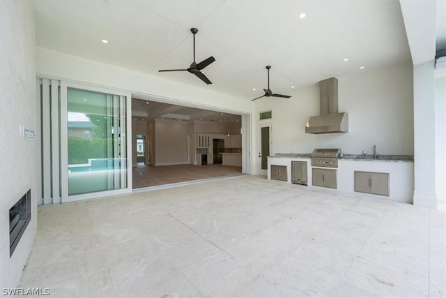 unfurnished living room featuring ceiling fan and sink