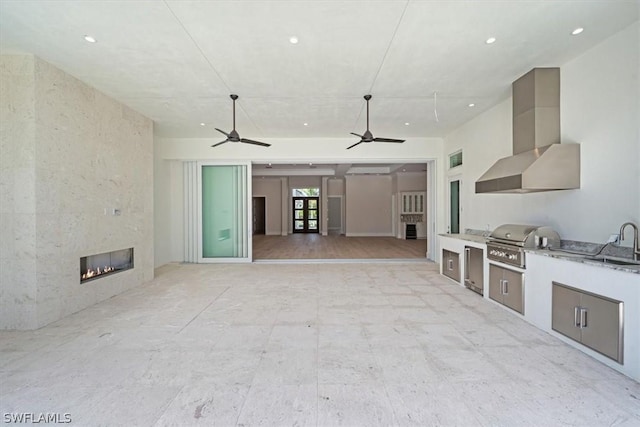 unfurnished living room featuring a fireplace, light hardwood / wood-style flooring, and sink