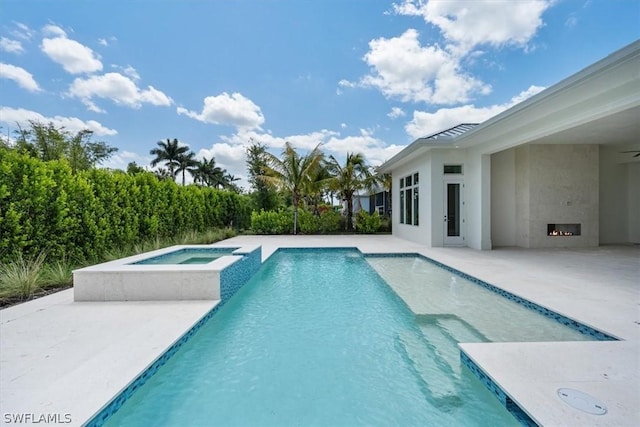 view of swimming pool with an in ground hot tub and a patio area