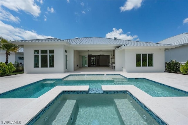 back of property with ceiling fan, a patio, and a pool with hot tub