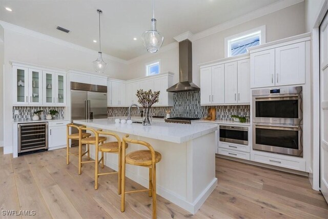 23517 Coconut Landing Dr, Estero, FL 34134 - kitchen with wall chimney exhaust hood, appliances with stainless steel finishes, beverage cooler, and crown molding