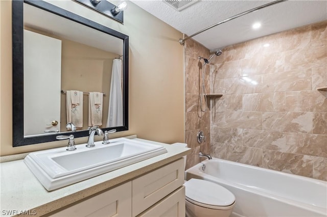 full bathroom featuring toilet, a textured ceiling, shower / bath combo with shower curtain, and vanity