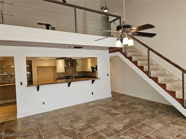 unfurnished living room with sink and ceiling fan