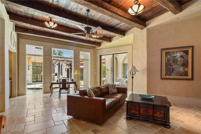 living room featuring beamed ceiling, ceiling fan, and wooden ceiling