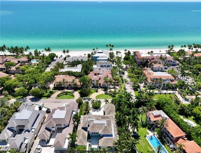 birds eye view of property with a water view and a beach view