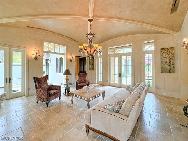 living room featuring french doors, an inviting chandelier, and vaulted ceiling