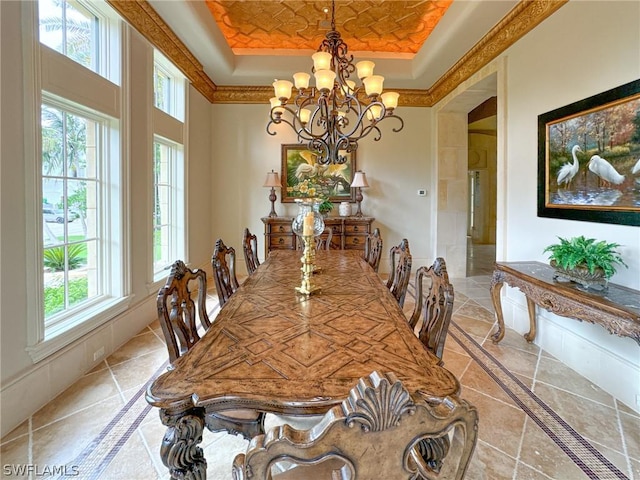 dining area with a notable chandelier, a wealth of natural light, and a tray ceiling