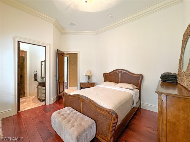 bedroom featuring ensuite bath, dark wood-type flooring, and ornamental molding