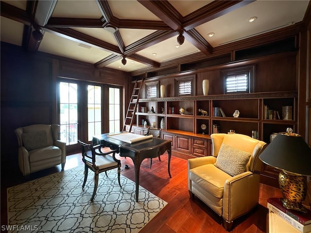 living area with beam ceiling, wood-type flooring, wooden walls, and coffered ceiling