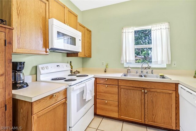 kitchen featuring white appliances, sink, and light tile patterned floors