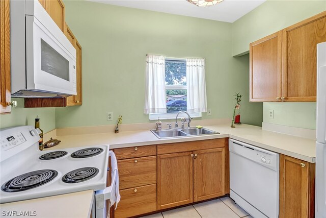 kitchen featuring sink, light tile patterned flooring, and white appliances