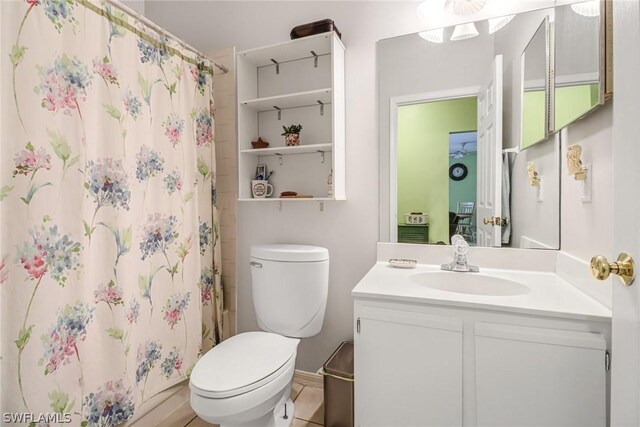 bathroom with tile patterned floors, vanity, toilet, and walk in shower