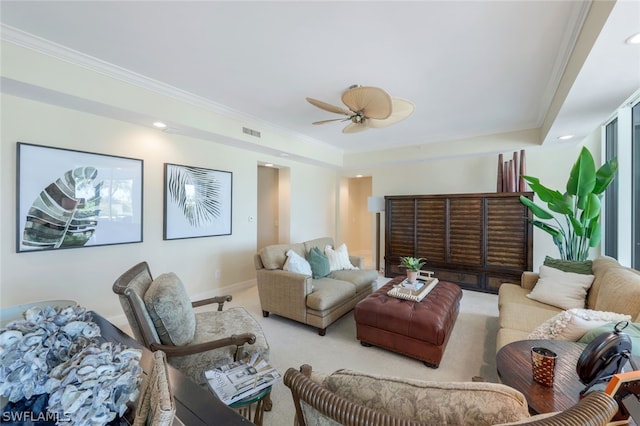 living room with a raised ceiling, ceiling fan, carpet, and ornamental molding