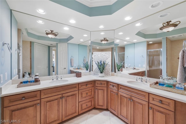 bathroom featuring a raised ceiling, tile patterned floors, crown molding, an enclosed shower, and vanity