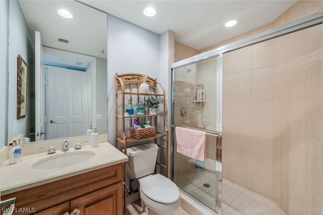 bathroom featuring vanity, a shower with shower door, and toilet