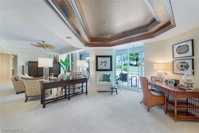 carpeted office with a raised ceiling, ceiling fan, and crown molding