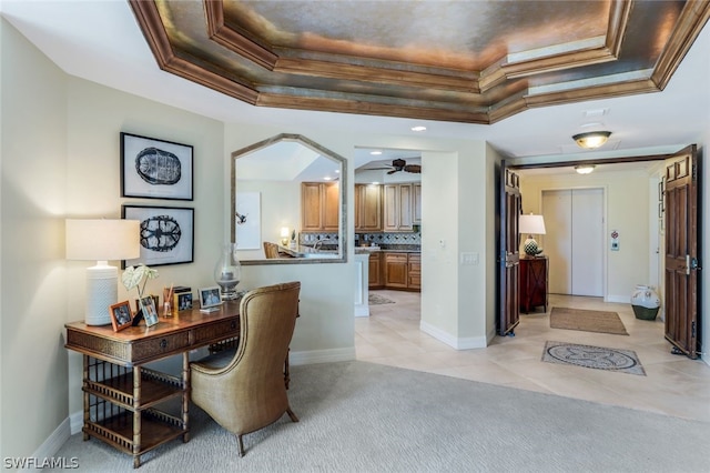 carpeted office space with ceiling fan, a raised ceiling, and ornamental molding