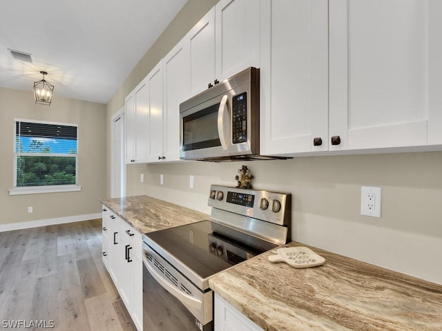 kitchen with white cabinetry, stainless steel appliances, and light wood-type flooring