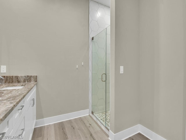 bathroom featuring wood-type flooring, vanity, and a shower with shower door