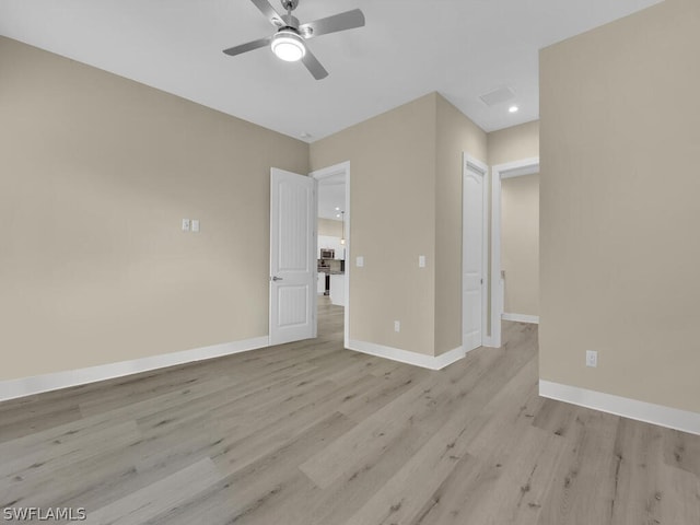 empty room with ceiling fan and light wood-type flooring