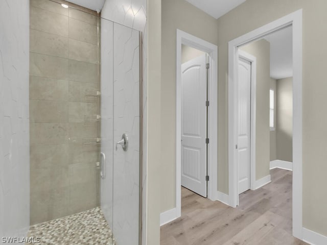 bathroom with hardwood / wood-style flooring and an enclosed shower