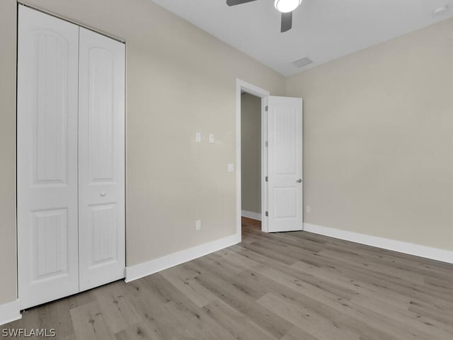 unfurnished bedroom featuring light wood-type flooring, a closet, and ceiling fan