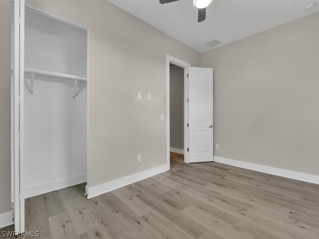 unfurnished bedroom featuring ceiling fan, light hardwood / wood-style floors, and a closet