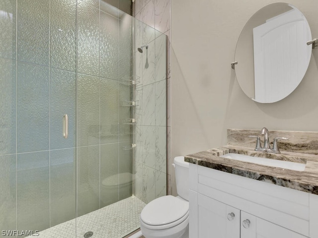 bathroom featuring an enclosed shower, vanity, and toilet