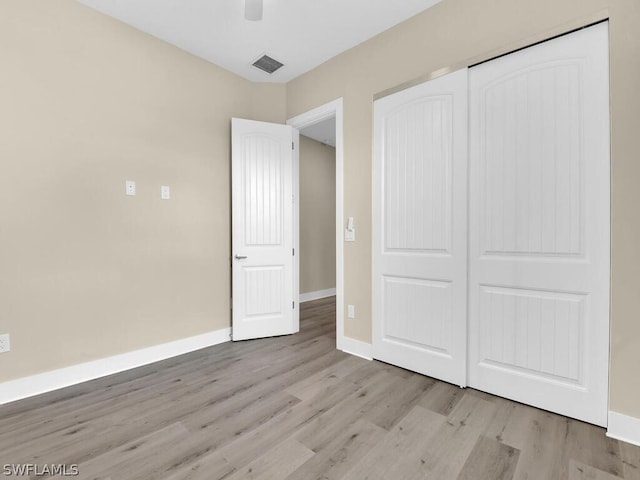 unfurnished bedroom featuring ceiling fan, a closet, and light hardwood / wood-style flooring