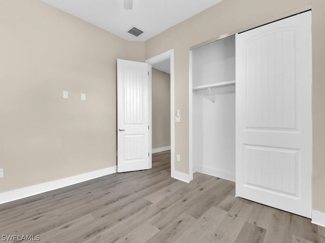 unfurnished bedroom featuring ceiling fan, a closet, and light hardwood / wood-style flooring