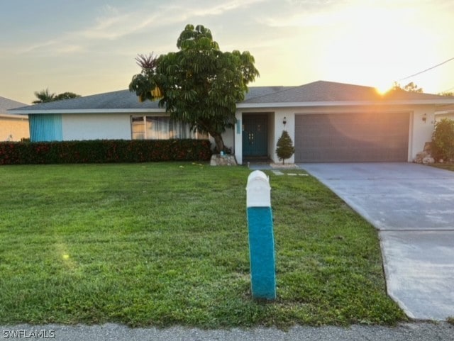 single story home featuring a yard and a garage