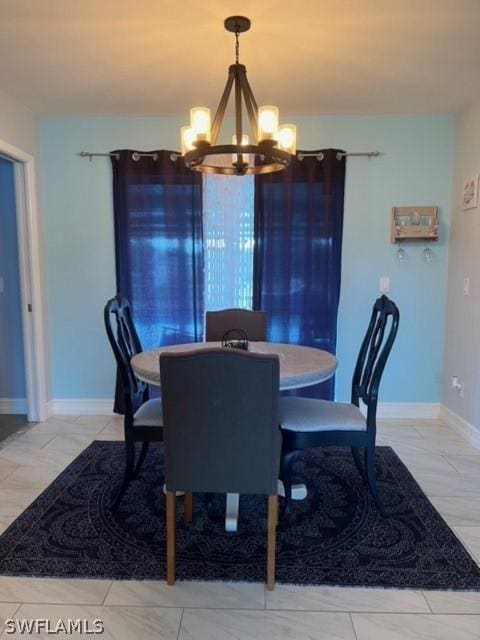 dining room with baseboards and an inviting chandelier