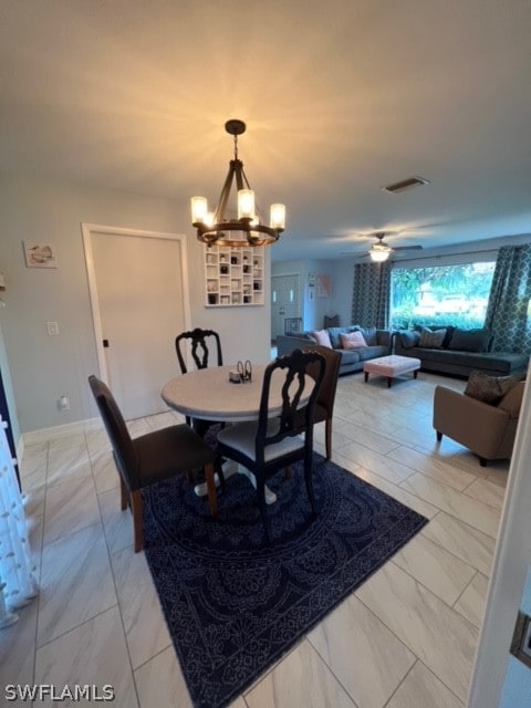 tiled dining room with ceiling fan with notable chandelier