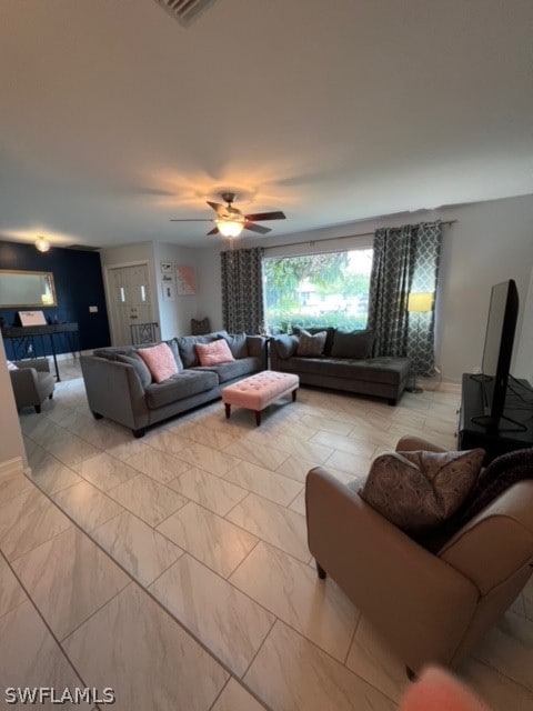 tiled living room featuring ceiling fan