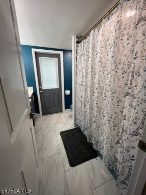 full bathroom featuring marble finish floor, curtained shower, and toilet