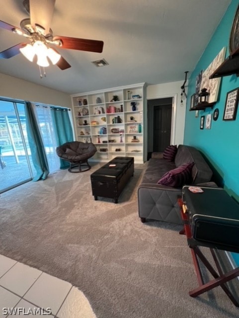 living area featuring a ceiling fan, visible vents, and carpet floors