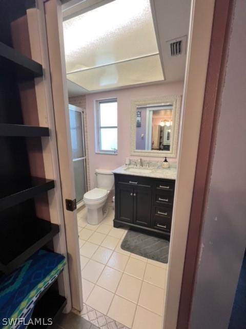 full bath featuring tile patterned floors, visible vents, toilet, a shower stall, and vanity