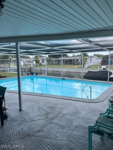 view of swimming pool featuring a patio and a lanai